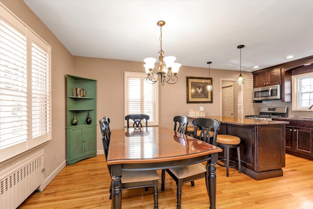 dining area featuring radiator, an inviting chandelier, and light hardwood / wood-style floors