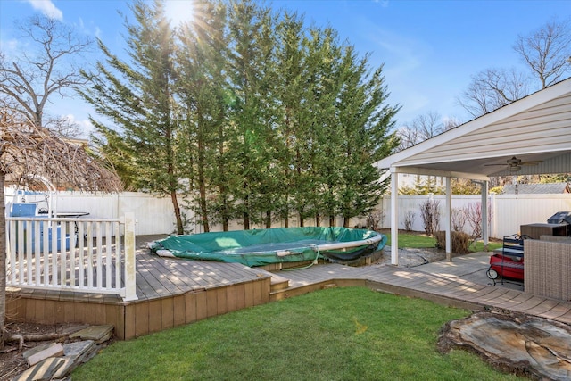 view of yard with ceiling fan and a deck