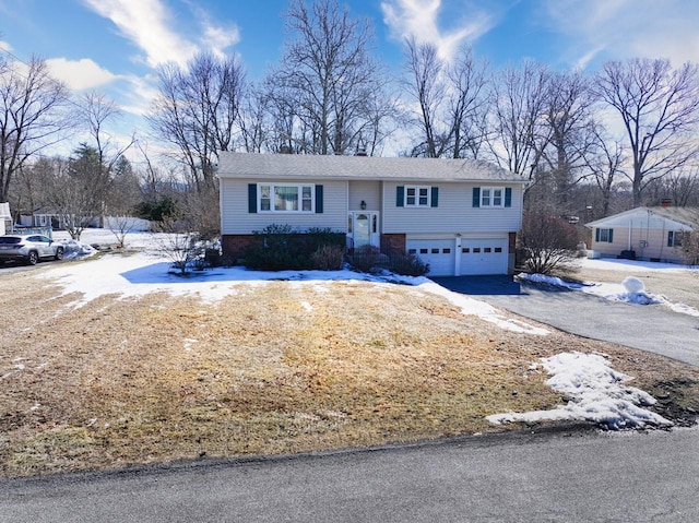 bi-level home featuring a garage and driveway