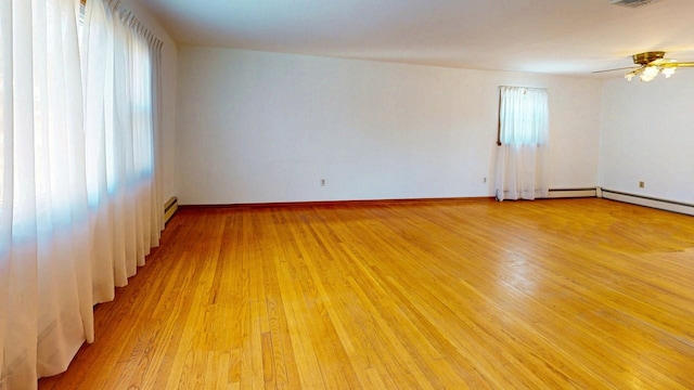 unfurnished room featuring visible vents, baseboards, ceiling fan, light wood-type flooring, and a baseboard heating unit