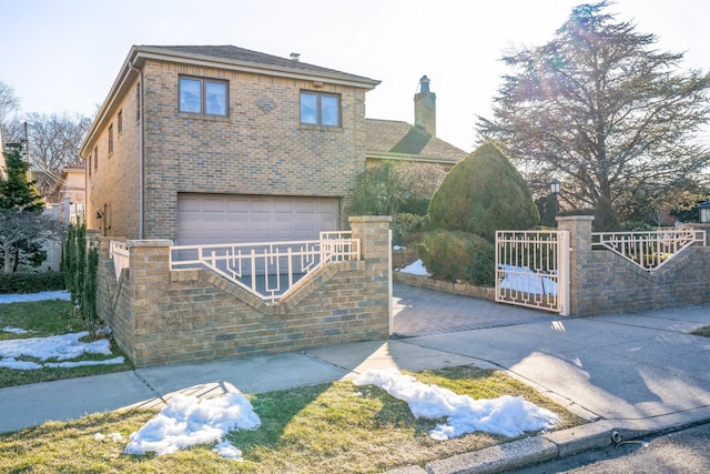 view of front of home featuring a garage, a fenced front yard, and brick siding