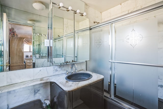 full bathroom featuring a shower with door and vanity