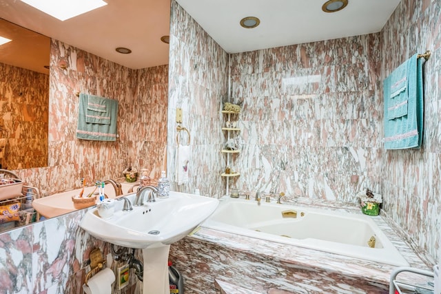 bathroom featuring a bath, a skylight, and tile walls