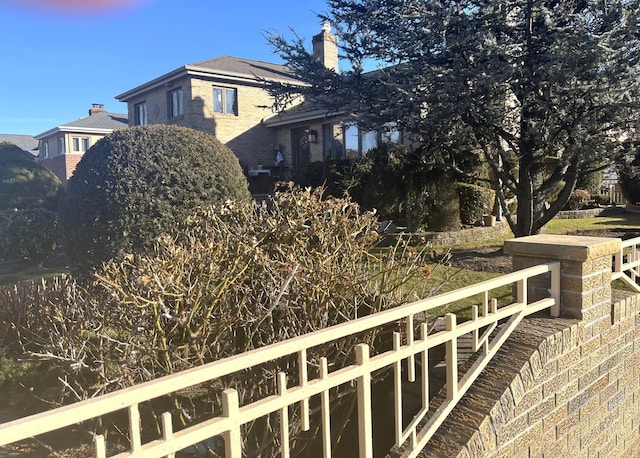 view of side of home featuring a chimney and brick siding