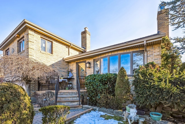 exterior space with brick siding and a chimney