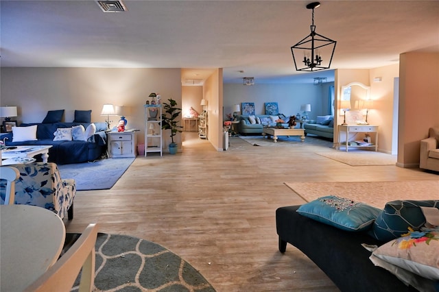 living room featuring an inviting chandelier and wood-type flooring