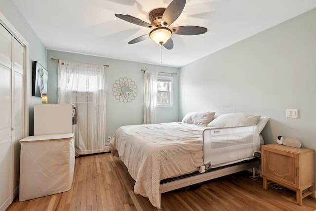 bedroom with light hardwood / wood-style flooring, a closet, and ceiling fan