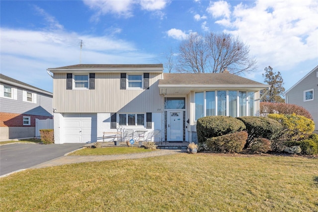 tri-level home featuring a garage and a front lawn