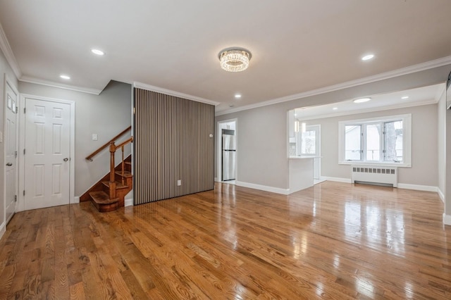 unfurnished living room with crown molding, radiator heating unit, and light hardwood / wood-style floors