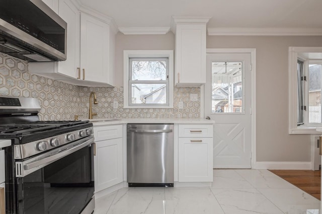 kitchen with appliances with stainless steel finishes, sink, white cabinets, backsplash, and crown molding