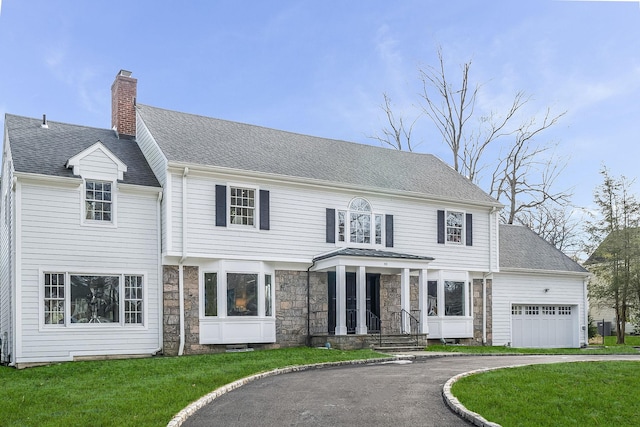 colonial house with a garage and a front lawn