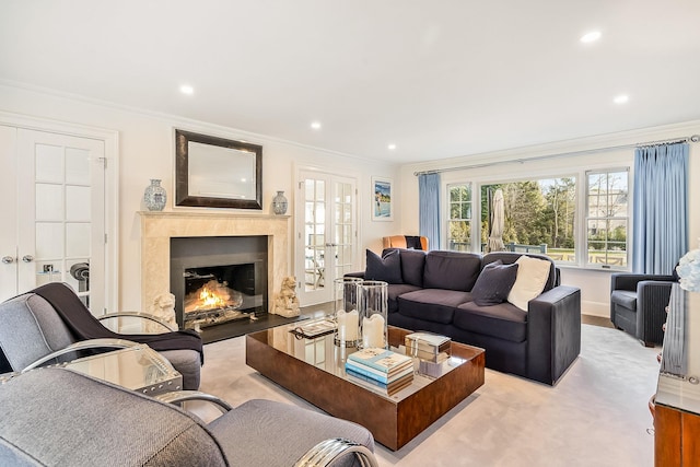 living room featuring french doors, a fireplace, crown molding, and light hardwood / wood-style flooring