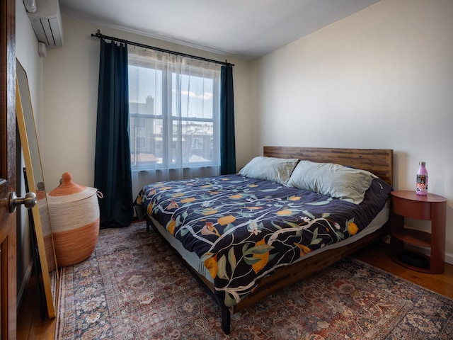 bedroom featuring an AC wall unit and dark wood-type flooring