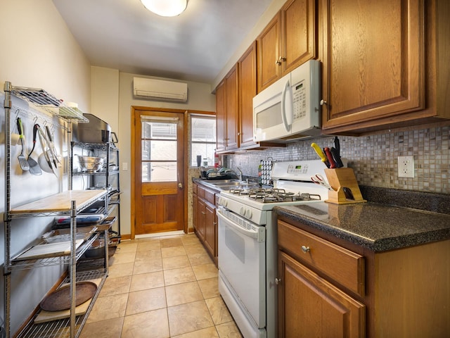 kitchen with sink, light tile patterned floors, white appliances, a wall mounted AC, and decorative backsplash