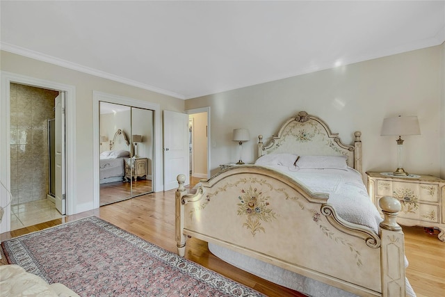 bedroom featuring crown molding, connected bathroom, hardwood / wood-style floors, and a closet