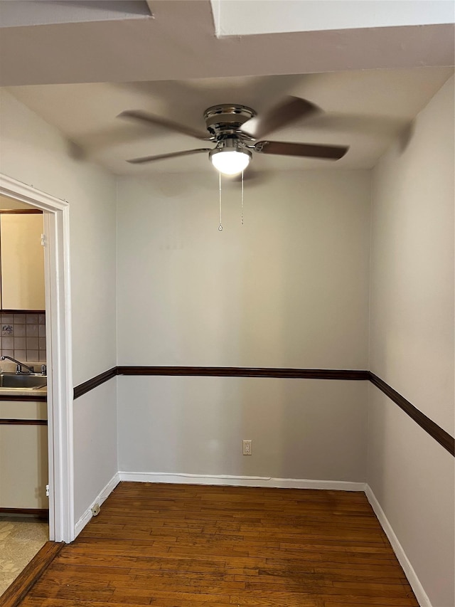 unfurnished room featuring wood-type flooring, sink, and ceiling fan