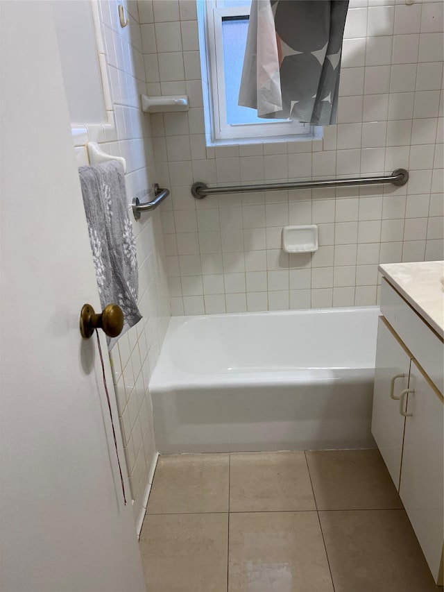 bathroom featuring vanity, tile patterned floors, and tiled shower / bath