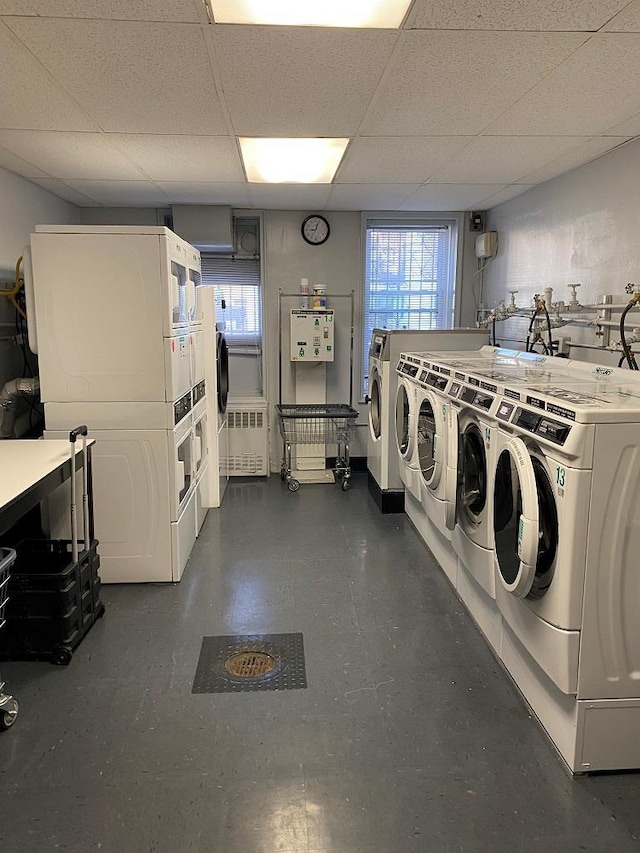 washroom with stacked washing maching and dryer, plenty of natural light, washer and dryer, and radiator heating unit