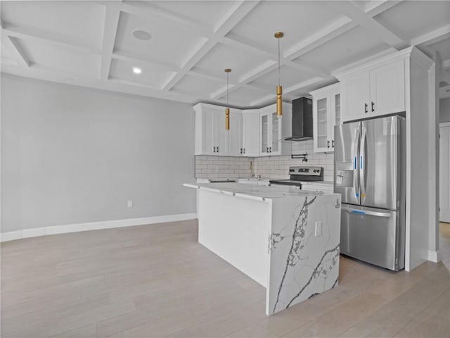 kitchen with coffered ceiling, white cabinetry, appliances with stainless steel finishes, pendant lighting, and wall chimney range hood