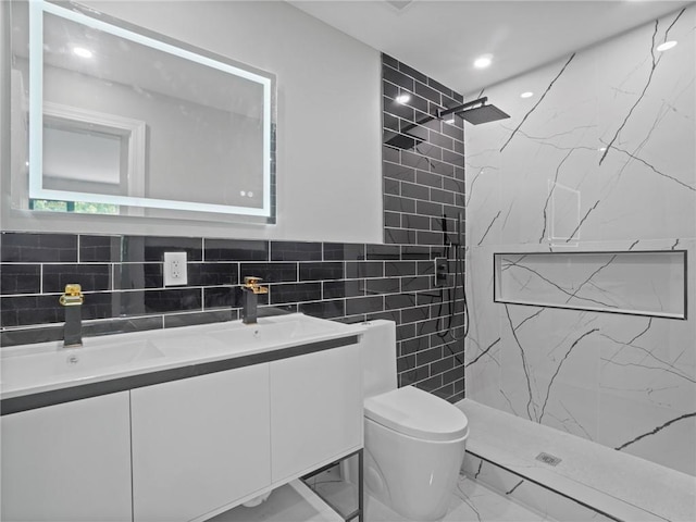 bathroom with tiled shower, vanity, and toilet