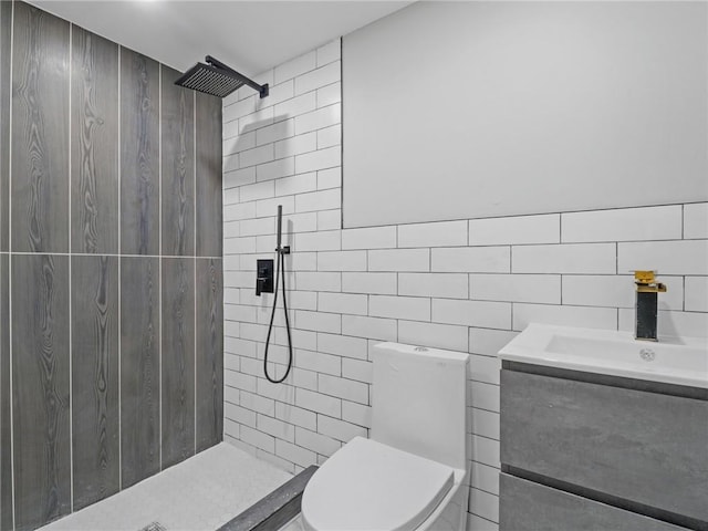 bathroom with tiled shower, vanity, and toilet