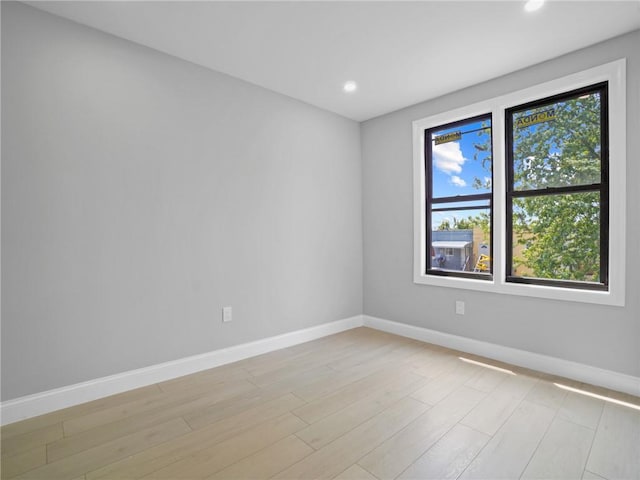 empty room with a healthy amount of sunlight and light hardwood / wood-style flooring