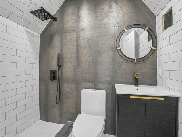 bathroom featuring lofted ceiling, toilet, tile walls, a tile shower, and vanity