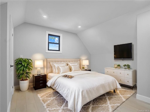 bedroom featuring light hardwood / wood-style flooring and vaulted ceiling