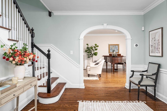 interior space featuring crown molding, arched walkways, and wood finished floors