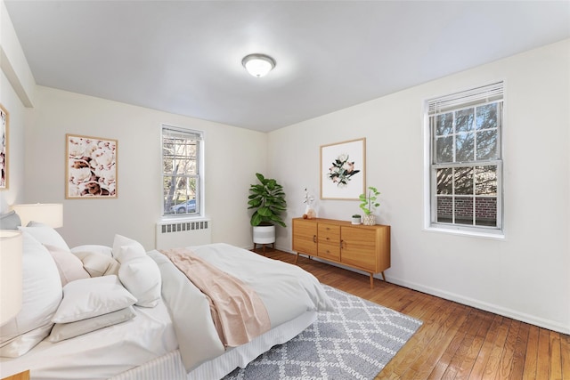 bedroom featuring hardwood / wood-style floors and radiator heating unit