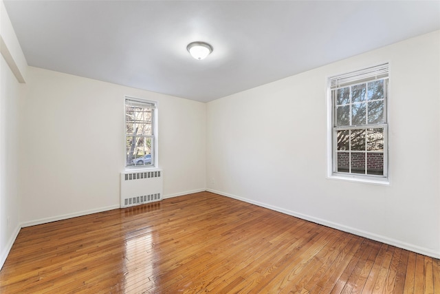 spare room featuring radiator and light hardwood / wood-style floors