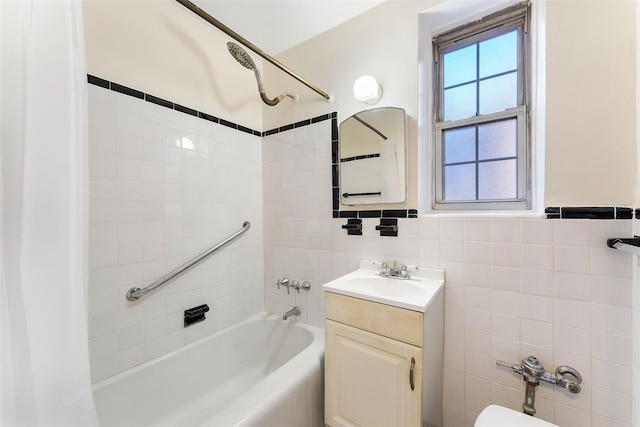 bathroom featuring vanity, tile walls, and tiled shower / bath