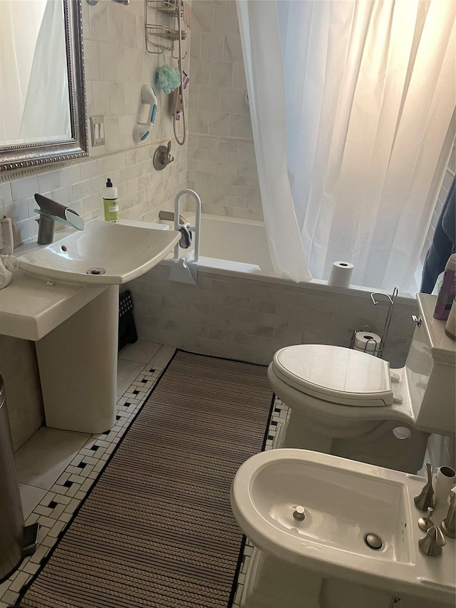 bathroom with a bidet, shower / tub combo with curtain, tile patterned flooring, tile walls, and toilet