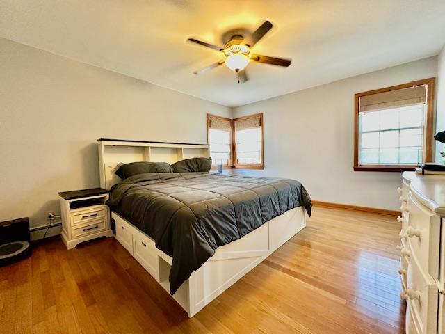 bedroom featuring a baseboard radiator, ceiling fan, and light hardwood / wood-style flooring