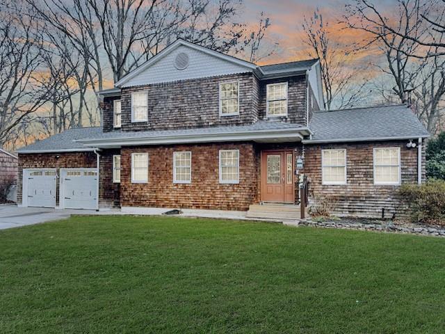 view of front facade featuring a garage and a yard