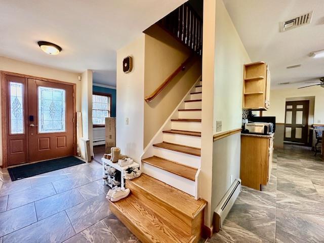 foyer with a baseboard heating unit and ceiling fan