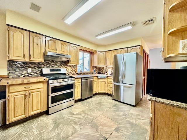 kitchen featuring light brown cabinetry, sink, decorative backsplash, and appliances with stainless steel finishes