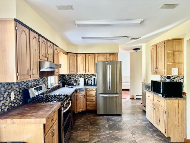 kitchen with decorative backsplash, a baseboard radiator, and appliances with stainless steel finishes