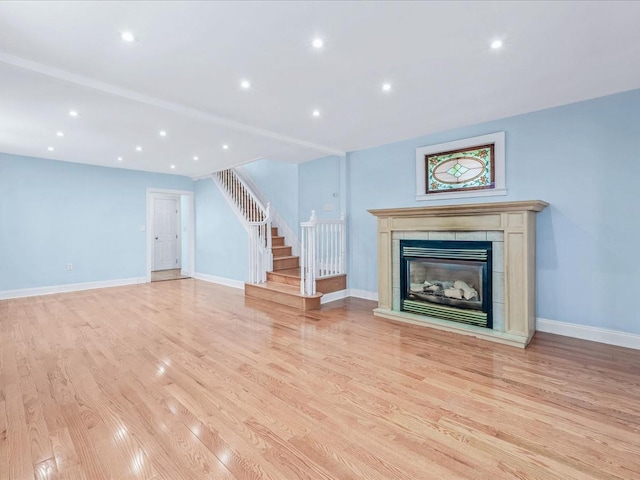 unfurnished living room with a fireplace and light hardwood / wood-style floors