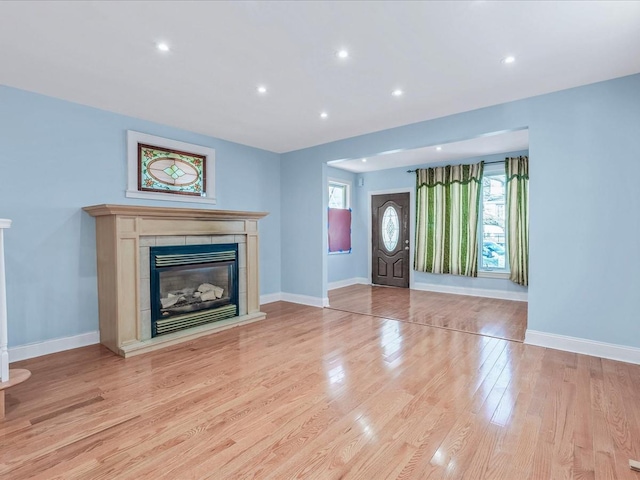 unfurnished living room with a fireplace and light hardwood / wood-style flooring