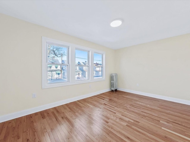 unfurnished room with radiator and light hardwood / wood-style floors