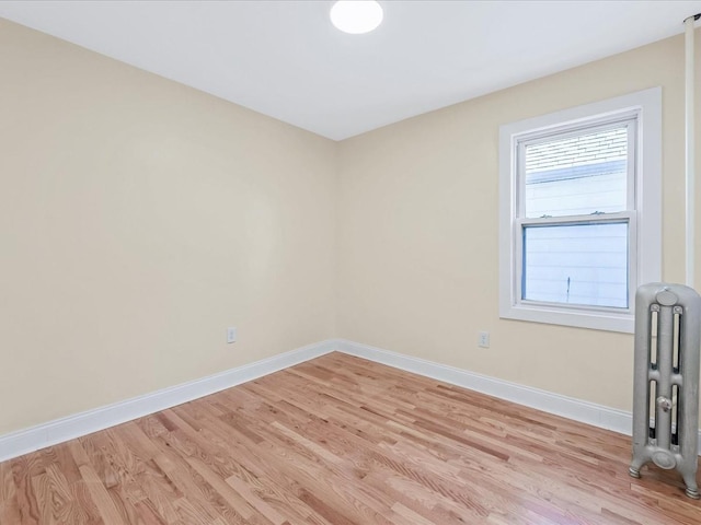 spare room with radiator and light wood-type flooring