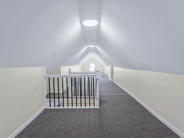 bonus room featuring lofted ceiling and dark carpet