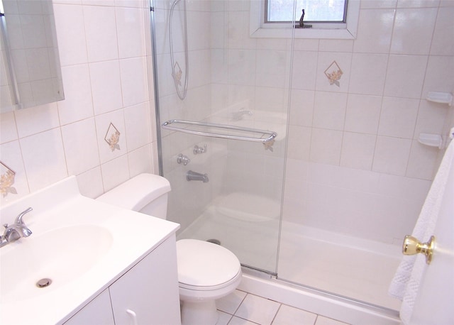 bathroom featuring tile walls, tile patterned flooring, vanity, toilet, and walk in shower