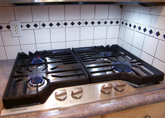 interior details featuring tasteful backsplash and gas stovetop