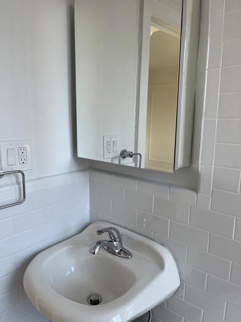 bathroom with tile walls and sink