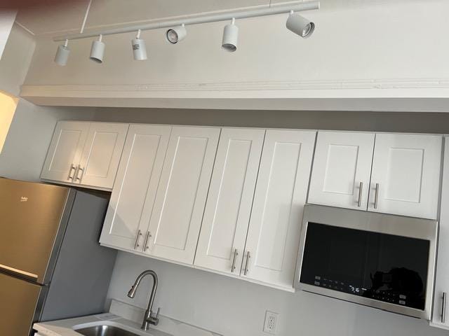 interior space with white cabinetry, sink, and appliances with stainless steel finishes