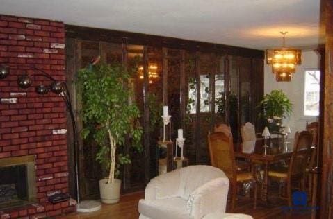 interior space featuring an inviting chandelier, wood-type flooring, and a fireplace