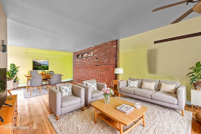 living area featuring baseboards, ceiling fan, and light wood-style flooring