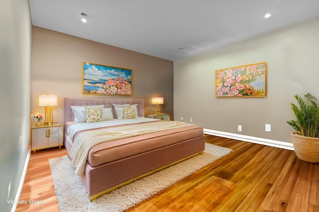 bedroom featuring baseboards, wood finished floors, and recessed lighting